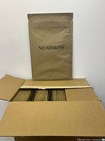 Open cardboard box with multiple brown kraft paper Curby mailers inside, showing quantity and condition.