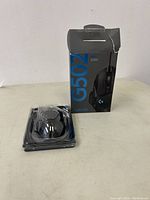 Photo showing Logitech G502 Hero gaming mouse in clear plastic tray, with accompanying box that shows slight damage.