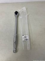 Full view of the Gearwrench long handle ratchet alongside its original packaging on a light-colored surface.