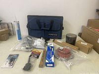 Overview photo showing all items including the Fortem organizer bag, various boxes, bags, and the magnetic pickup tool package.