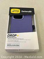 Front view of the purple Otter Defender case inside original packaging, showing branding and model compatibility.