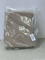 Light brown velvet blanket folded and sealed in clear plastic packaging showing size sticker 80 x 90 inches and material label 100% nylon.