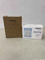 Both Addtam and Huntkey wall plugs in their original packaging with visible branding and product details.