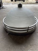 Side angle showing frosted white glass dome with subtle swirls and metal ring frame with central finial.