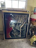 Framed large wall art showing a resting cheetah with a nature scene background, glittering gold textures, and black layered glass sections for depth.