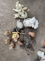 Top-down view showing the bear lying on its back, three small deer, two small pigs, a snail, a fairy pot/stand, and a gnome headpiece, highlighting their condition and size.