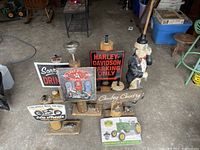 All signs and statue arranged on floor, shows six signs and one statue, illustrating size and condition.