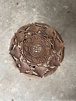 Top view of the round wooden table top with detailed floral and leaf carvings.
