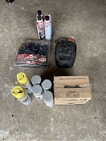 Overview photo of all items including spray paints, cargo nets, box, and car wax sprays.