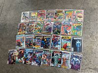 Top view of 29 Superman comics laid out on a concrete floor, showing a variety of covers and editions.