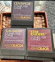 Front view of three Atari game cartridges showing labels for Centipede CXL4020, Galaxian CXL4024, and Star Raiders CXL4011.