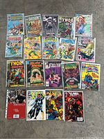 Top-down photo showing 19 bagged comic books including Spider-Man, Thor, Green Lantern, Hawkman, and more.