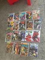 Photo showing 19 older comic books in protective bags grouped on a surface.