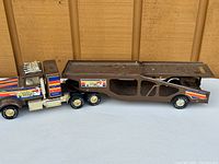 Full side view of the entire Muscle Mover car hauler, showing the truck and trailer, highlighting length and overall design.