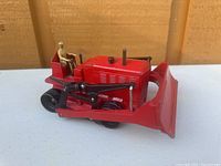 Red Dinky Mecano bulldozer toy, side view showing details and seated figure