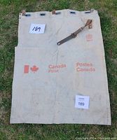 Full view of the Canada Post canvas mail bag showing branding, leather strap, and top grommets.