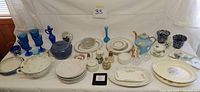 Full lot overview showing blue-themed kitchen items including plates, pot, goblets, and small decorative pieces.