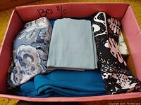 Box containing a mix of floral, solid blue, black and white patterned fabric pieces