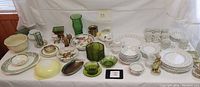 Full display photo of all the items in the lot showing china, glassware, and decorative pieces