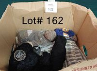 Box view showing various yarn balls and a portion of a knitted piece inside the box.