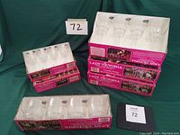 Full view of multiple unopened boxes of Lady Victoria fine crystal stemware showing tall and medium glasses in original packaging.