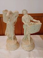 Both large figurine planters together on a white cloth, showing front view.