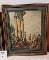 Framed vintage Roman scene print showing classical ruins with large columns and figures in period attire, framed in gold and dark green wood frame.