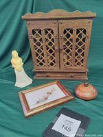 Wide shot showing all four items in lot: vintage wooden spice rack, woman figurine, dried flower framed art, small lidded wooden bowl.