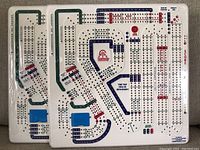 Two new Crib Wars Cribbage Boards side by side, showing the white hard plastic construction with colored scoring tracks and peg holes.