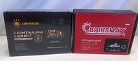 Front view of two boxed LED lighting kits for Lego, one Lightailing and one Briksmax, showing brand names and packaging details.