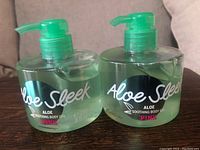 Two new bottles of Victoria's Secret Pink Aloe Sleek Aloe Soothing Body Gel with green pump tops and green gel visible inside clear bottles.