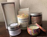 Five candles displayed together showing variety in containers and labels