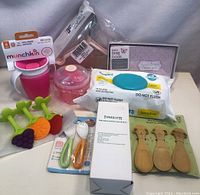Full view of all baby products including sippy cup, teething toys, spoons, wipes, lotion, book, and food container