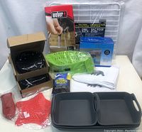 Overview of kitchen housewares including griddles, sink rack, citrus juicer, oven mitts, towel and ceramic scrubbing pads.