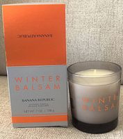 Photo showing the Banana Republic Winter Balsam scented candle next to its original box, confirming new and unused condition.