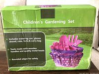 Box of new children's gardening set showing product image and features including watering can, gloves, shovel, rake, fork, and carry bag