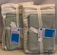 Two bundled sets of dishcloths and towels with Room Essentials labels showing each set contains 2 dishcloths and 1 towel.