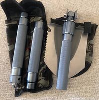 Foldable shovel disassembled and assembled on top of camo pouch