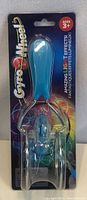 Photo of a new Gyro Wheel toy in packaging with a blue handle and transparent spinning wheel. Light-up effects advertised on packaging.