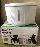 Photo of new pet drinking fountain on its box with 2L capacity and silhouettes of dog and cat on box