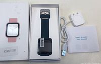 New black smart bracelet watch in original box with USB charger and user manual.