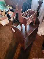 Wooden reindeer planter on top of a small book case, with visible plant holder and reindeer features.