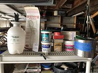 Flo-Master 1 gallon liquid sprayer along with various containers of flooring adhesives and repair tools on shelf