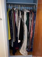 Closet view showing multiple women's clothing items on hangers, various colors and prints including leopard and plaid.
