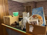 View showing boxed Tupperware containers alongside ceramic dish, boxes, and small decorative items on a dark surface.
