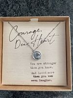 Full view of necklace in box with inspirational message insert.