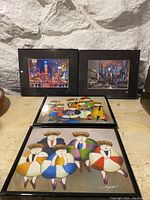 Photo showing all four framed prints arranged with Times Square scenes in back and abstract figure prints in front.