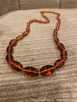 Full view of the amber necklace showing string of graduated oval amber beads.