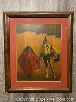 Front view of the framed painting showing two figures walking with a red mat and wooden frame.