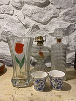 Photo showing the full lot of retro glass and ceramic items against a stone wall background.